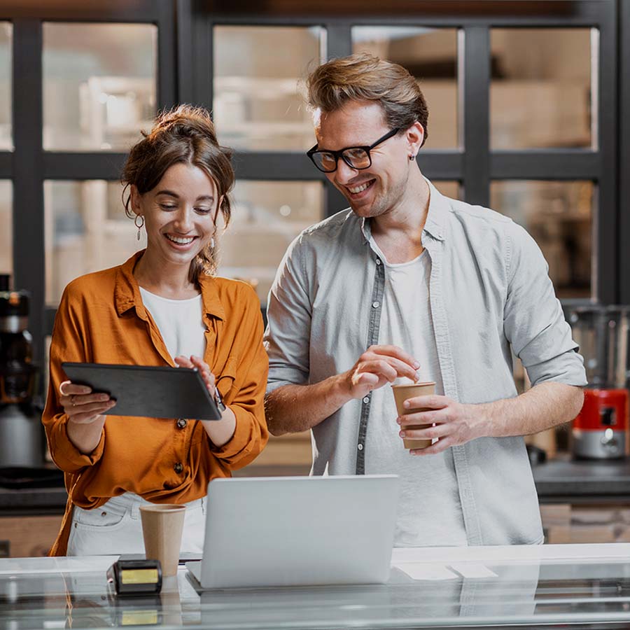 Smiling woman and man private entrepreneurs explore the benefits of Visa on a tablet